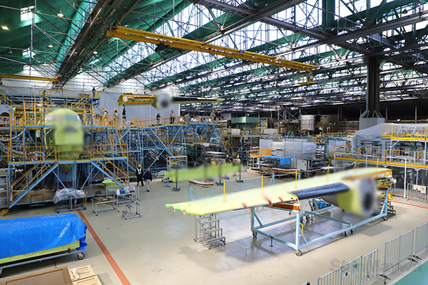 工場の天井にはクレーンがあり、作業も効率的に行えます。手前には右主翼も置かれていますね。