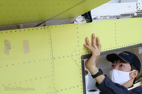 This is also a kind of block method. The bulge made in advance is brought into close contact with the fuselage and fixed with pins (the worker wears a head protector inside the hat).