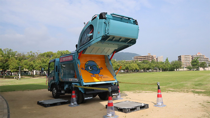 環境学習用塵芥車　排出時には、宝塚市環境部のシンボルキャラクター“あーすちゃん”が描かれた排出板がお目見えします。