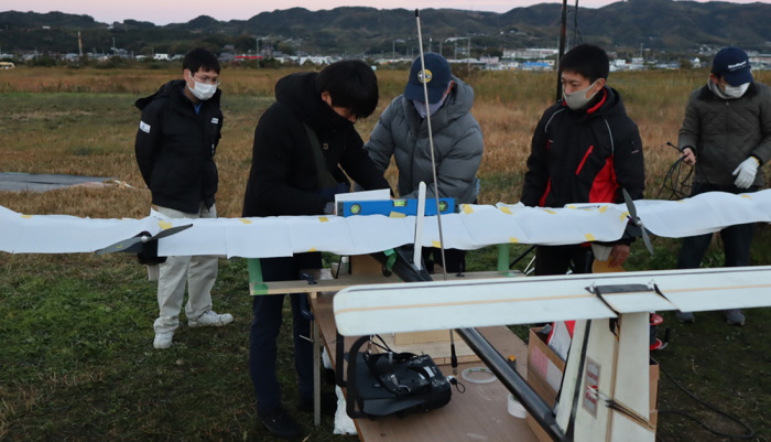 (1) 飛行に向けて機体の調整を重ねる開発メンバー